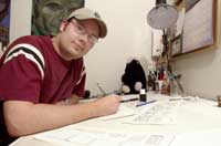 Cartoonist Jason Kotecki at the drawing board in his home studio. (Photo by Henry A. Koshollek)